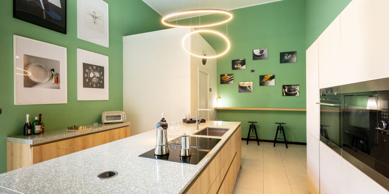 stone-italiana-cucina-moderna-in-quarzo-terrazzo-vedere-isola-centrale-muro-verde